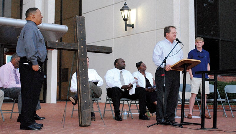 DAILY LEADER / RACHEL EIDE / Accepting Mission Mississippi's lighted cross Friday night on behalf of Lincoln County are Chancery Clerk Tillmon Bishop (at podium) and the Rev. Phillip Sterling (left). Also on hand was Connor Crosby (far right), from Loyd Star Attendance Center, who was leading the group of athletes taking the cross on the next stage of its journey. 