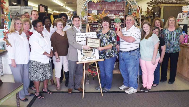 DAILY LEADER / With chamber officials, store employees and well wishers looking on, Brookhaven-Lincoln County Chamber of Commerce Executive Director Garrick Combs presents the Small Business of the Month Award to Rhonda and Billy Joe Deer, owners of Vendors Emporium, on Tuesday.