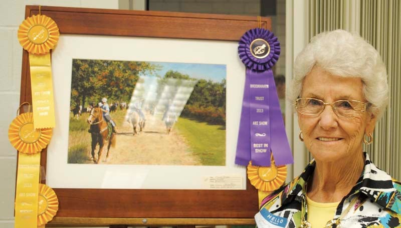 DAILY LEADER / JUSTIN VICORY / Gwin Robertson stands next to her painting, "Trail Ride," which won five separate awards in the Brookhaven Trust Fine Arts Committee's art competition Thursday, including Best of Show. 