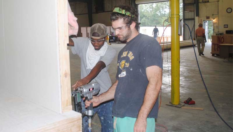 DAILY LEADER / JUSTIN VICORY / Lance Waldrop and Garland Ramsey, both from Brookhaven, frame one of the walls to a modular unit, just one step in a multi-layered assembly line process.