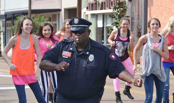 DAILY LEADER / RACHEL EIDE / Sgt. Kenneth Collins, off duty Sunday from the Brookhaven Police Department, and the Showstoppers dancers perform some fancy footwork on Cherokee Street Sunday.