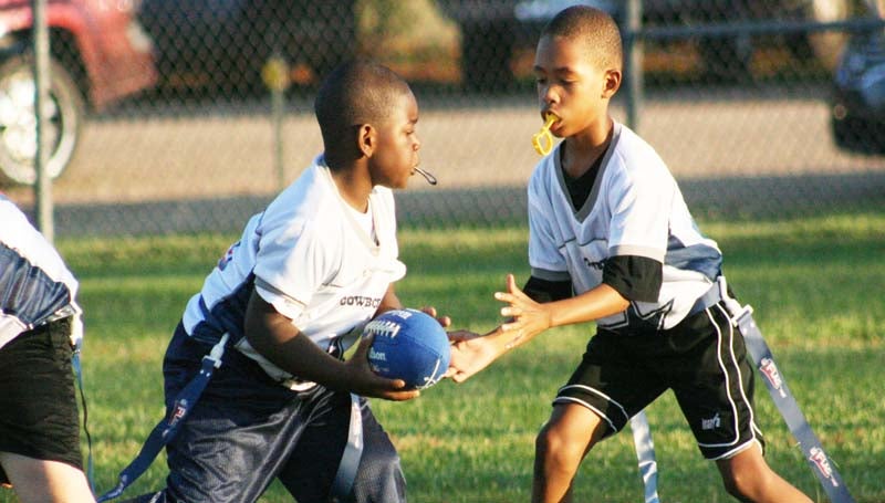 Cowboys quarterback Lajavion Nelson hands off to his teammate, Tyquarius Terrell in Tuesday's  BRD Flag Football action at the Hansel King Sportsplex.