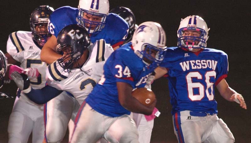 DAILY LEADER / TRACY FISCHER / Wesson running back Otis Smith (34) plows through Franklin County's defense as teammates Justin Boone (66) and Chase Twiner (76) hold off FCHS defender Darrin Wiley (3) Friday night.