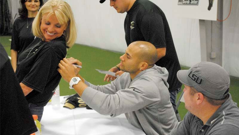 DAILY LEADER / Wide receiver of the New Orleans Saints, Lance Moore, signs the back of Carole Thompson's shirt at the King's Daughters Medical Center autograph signing event Monday night at the KDMC Performance Center.