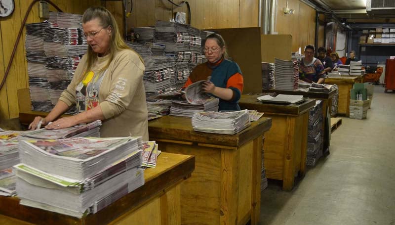 THE DAILY LEADER / RACHEL EIDE / The Daily Leader mailroom staff members, including (from left) Mary Temple, Lee Marbury and others, work to assemble today's big holiday edition of the newspaper, which is being delivered to all local residents as The Daily Leader's gift to the community. Some 19,000 copies of the newspaper will be distributed today.