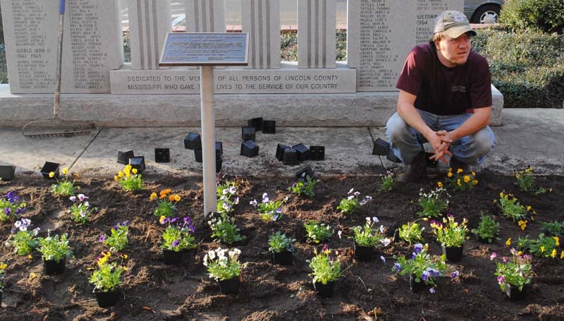 THE DAILY LEADER / JUSTIN VICORY / Gage Gatlin takes a short break after planting flowers in front of the Brookhaven-Lincoln County Government Complex Tuesday afternoon.