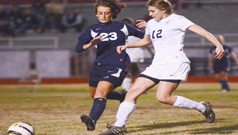 DAILY LEADER / SCOTT BOYD / Brookhaven High's Katie Grace Culpepper (12) battles with Pearl's Kelli Green in Tuesday night's soccer game in Brookhaven. The Lady Panthers (5-7-2) lost to Pearl 4-0. In the boys' game, the Pirates defeated the Panthers (2-10-2) 9-0. With the loss, Brookhaven still clinched second place in district action and made the playoffs that starts Jan. 28. 