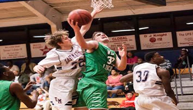 DAILY LEADER / TERESA ALLRED / West Lincoln's Sam Bivens shoots a tough shot under the basket as East Marion's defender Tre Tolar (32) tries to block the attempt Friday night.