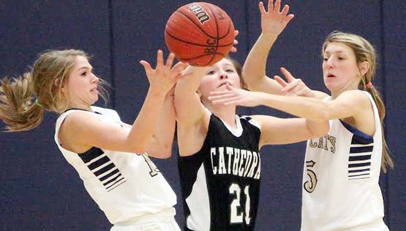 DAILY LEADER / JONATHON ALFORD / Bogue Chitto's Mattie Avants (left) and Terrah Nelson (5) knock the ball away from Natchez Cathedral's Caroline Smith (21) Friday night.