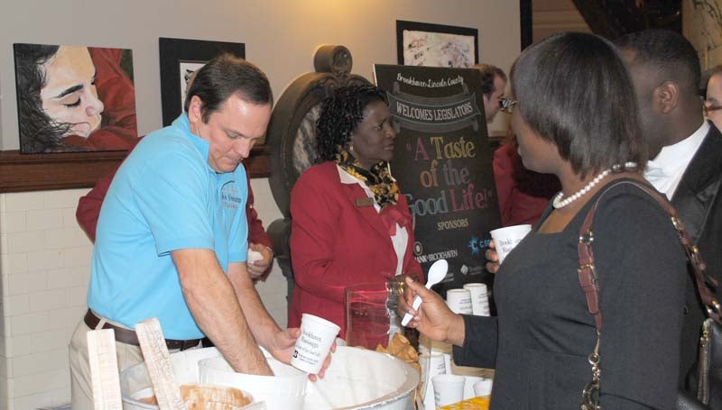 Mark Crosby of the Mississippi Ice Cream Factory in Brookhaven scoops some ice cream for Mildred Michael from Mississippi Valley State University at the Brookhaven Day at the Capitol social event Tuesday.