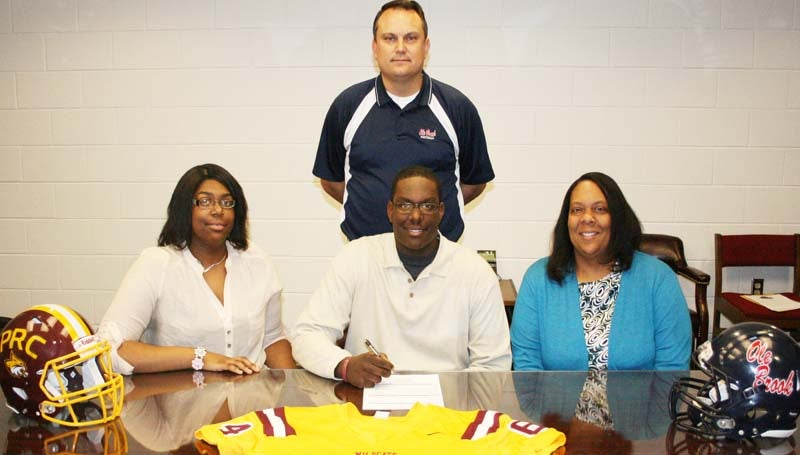 DAILY LEADER / MARTY ALBRIGHT / NELSON SIGNS WITH PEARL RIVER - Brookhaven offensive lineman Keefa Nelson has signed with the Pearl River Community College Wildcats. Pictured with Nelson are his sister, Erica Nelson, (left) his mother, Ursula Nelson, and (standing) Brookhaven head coach Tommy Clopton.