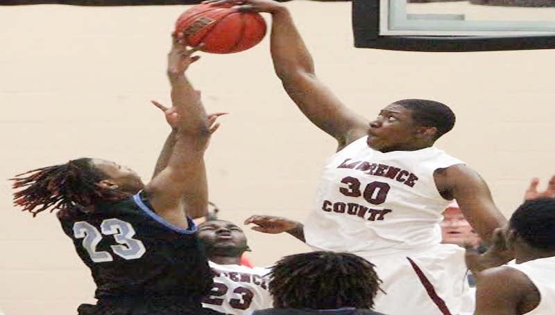 DAILY LEADER / JONATHON ALFORD / Lawrence County's La'Brian Bass (30) collects a monstrous block for the Cougars against North Pike's D'Hendrick Wells (23) and goes in for a layup Friday night.