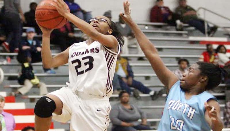 DAILY LEADER / JONATHON ALFORD / Lawrence County's Latasha Rhodes (23) drives in for a layup as North Pike's defender Ambreinna Brown (20) hustles back to deny the attempt Friday night.