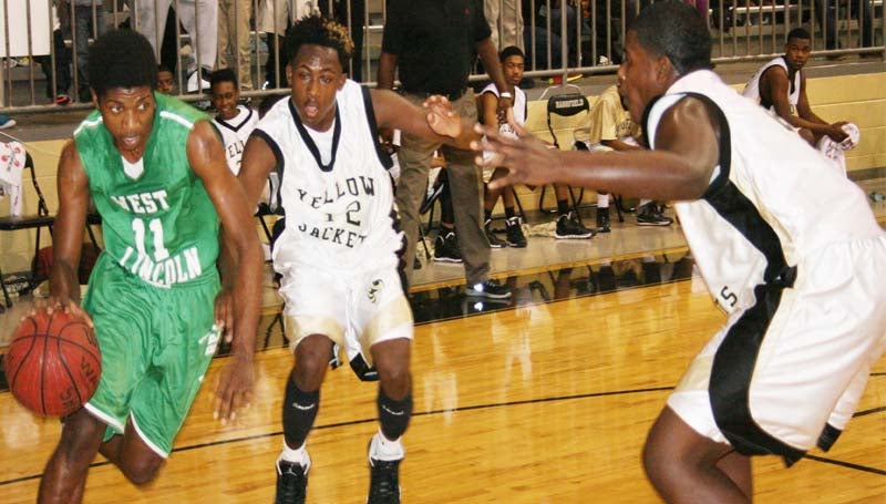 DAILY LEADER / MARTY ALBRIGHT / West Lincoln's Keshaun London (11) drives the baseline to score as Bassfield's defenders Xavier Harper (12) and Jonathan Holloway apply pressure Friday night.