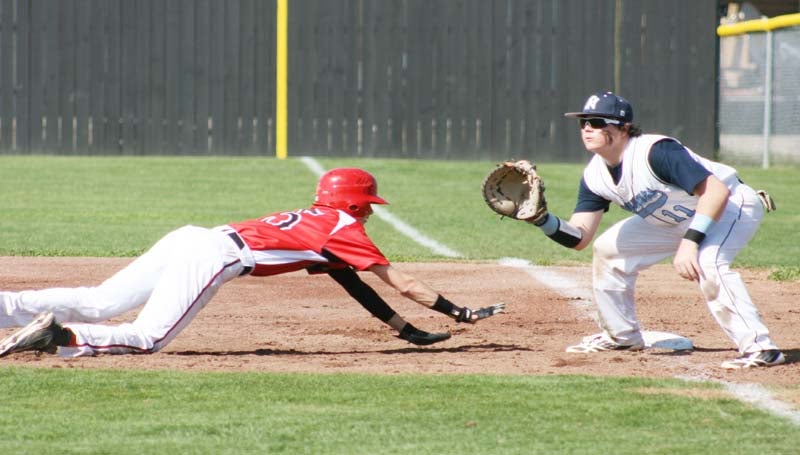 DAILY LEADER / MARTY ALBRIGHT / Loyd Star's Caleb Yarborough (15) dives back to first base to avoid a pick off as North Pike's first baseman Dallas Smith waits on the throw Monday in baseball action at Lawrence County.