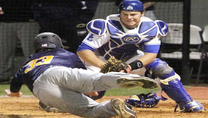 DAILY LEADER / SHERYLYN EVANS / Co-Lin catcher Logan Smith (25) blocks the plate to tag out Gulf Coast runner Matt Trigg (33) sliding in Game Two of the doubleheader.