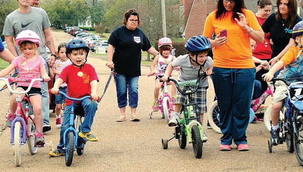 THE DAILY LEADER / JUSTIN VICORY / A flurry of bikes, tricycles, scooters and even motorized vehicles circled around the block Wednesday morning as part of First United Methodist Church's annual "Trikathon" event. Among the riders are (from left) kindergarten class members Lilly Jones, Riley Touchstone and Sawyer Boyd.