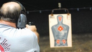 The Bullet Hole Indoor Range owner Richard Goss lines up a target recently.