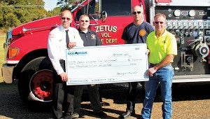 From left, Zetus Volunteer Fire Department Chief Dale Anding, treasurer Jonathon Alford and firefighter Linc Tucker receive a check from Brookhaven Georgia Pacific Mill Manager Larry Forman for the 2015 GP Bucket Brigade Grant. The $4,000 grant will be used to purchase new turnout gear. 