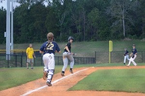 Photo by Anthony McDougle/ Dillon Reeves of Alexander Gold heads for third base in an effort  to evade a tag from Bogue Chitto catcher Shaw King during the early innings of their Thursday night contest. Reeves had two singles in the game to help Alexander Gold win 10-5 over Bogue Chitto. 